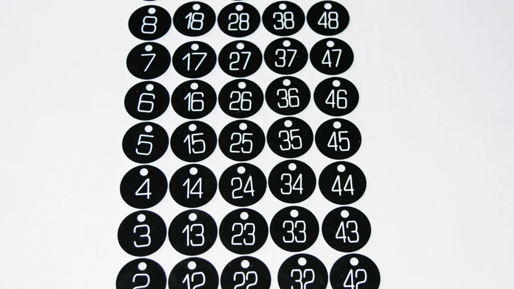 Black numbered asset identification discs arranged in a production set